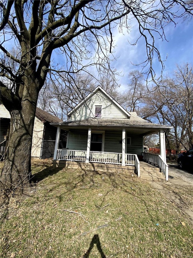 view of front of property with an attached carport, covered porch, and roof with shingles