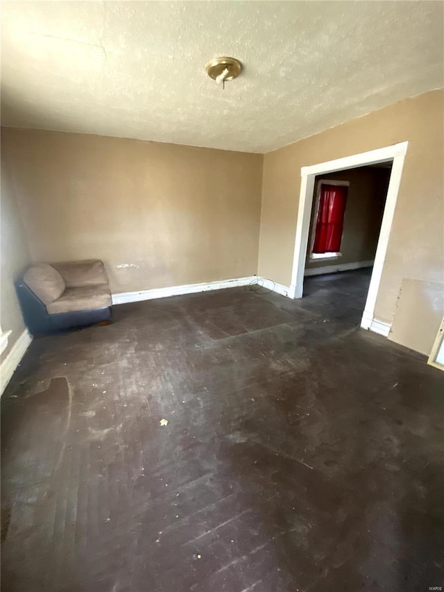 unfurnished room featuring baseboards and a textured ceiling