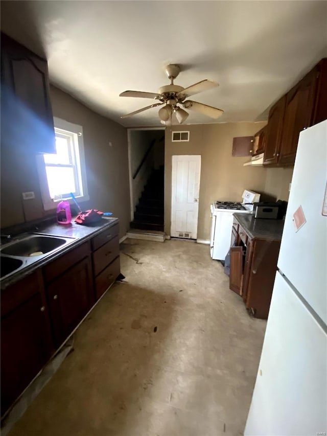 kitchen featuring white appliances, visible vents, ceiling fan, a sink, and dark countertops