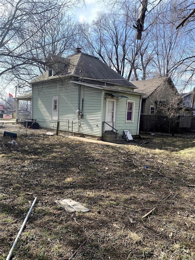 rear view of property with entry steps and fence