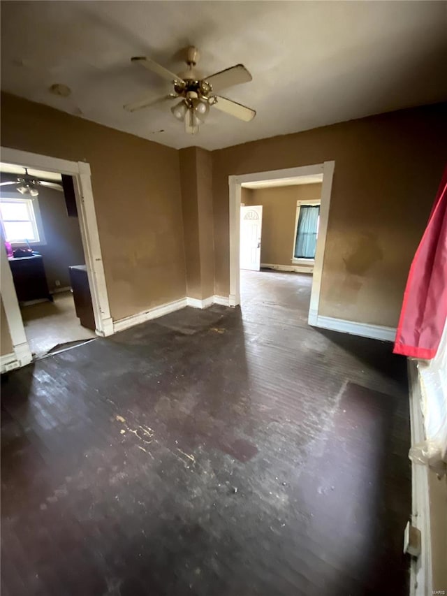 spare room with baseboards, concrete flooring, and a ceiling fan