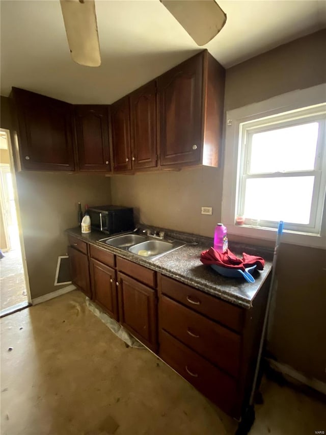 kitchen with dark countertops, visible vents, concrete flooring, and a sink