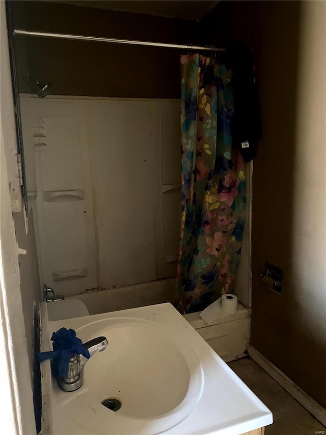 bathroom featuring shower / bath combo, baseboards, and a sink