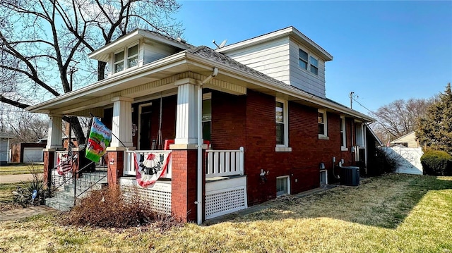 view of side of home with central AC unit, covered porch, and a yard