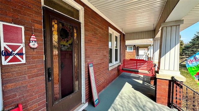 exterior space with brick siding and covered porch