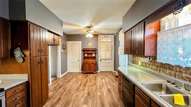 kitchen featuring ceiling fan, light countertops, black dishwasher, light wood-style floors, and a sink