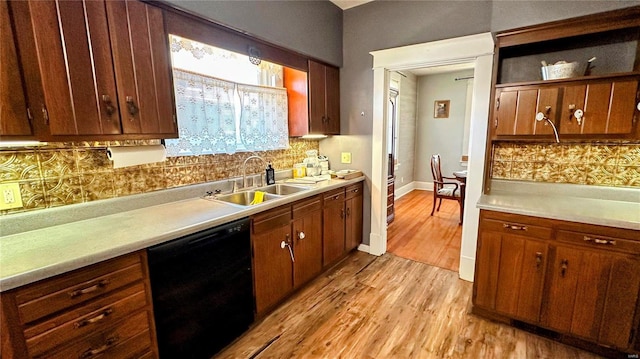 kitchen with light wood finished floors, light countertops, black dishwasher, decorative backsplash, and a sink