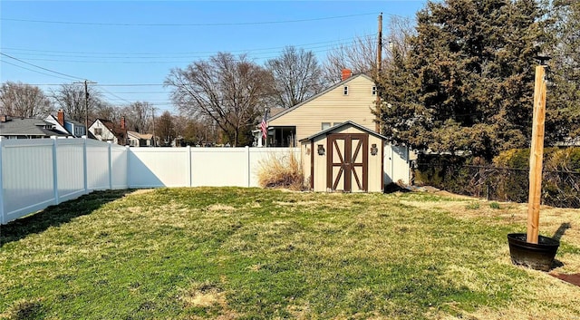 view of yard with an outbuilding, a fenced backyard, and a shed