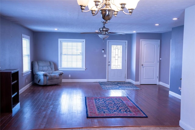 entryway with ceiling fan with notable chandelier, baseboards, and wood-type flooring