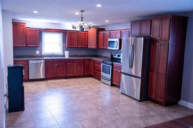 kitchen featuring a notable chandelier, a sink, stainless steel appliances, dark brown cabinets, and hanging light fixtures