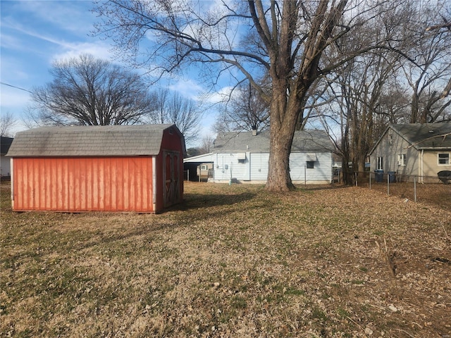 view of yard featuring a storage unit, an outbuilding, and fence