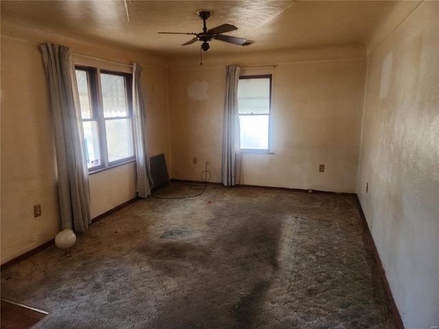 carpeted spare room with baseboards and a ceiling fan