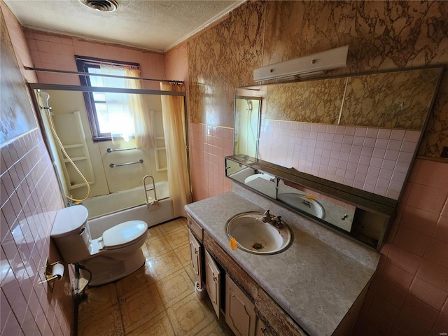 bathroom with tile patterned floors, a textured ceiling, tile walls, and shower / bath combination with glass door