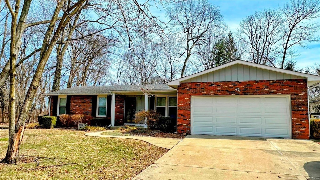 ranch-style home with a front lawn, driveway, board and batten siding, a garage, and brick siding