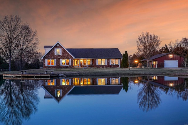 back of property featuring an outdoor structure, a water view, and a detached garage