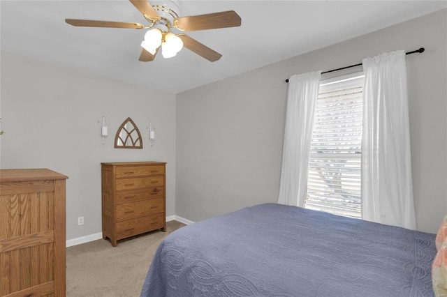 bedroom with light colored carpet, baseboards, and ceiling fan