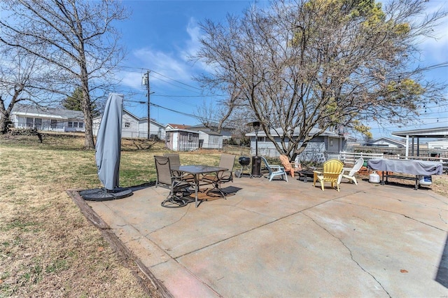 view of patio / terrace with an outbuilding, a storage unit, and fence