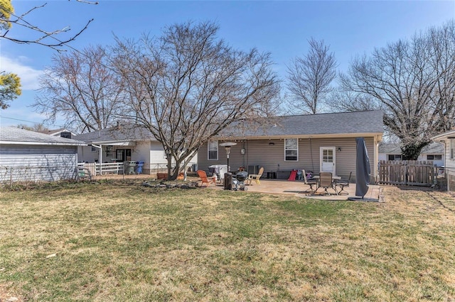 rear view of house featuring a patio, a lawn, and fence