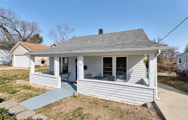 bungalow with a porch, a chimney, an outdoor structure, and a shingled roof