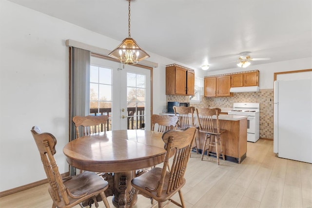 dining room featuring ceiling fan with notable chandelier, french doors, baseboards, and light wood-style floors