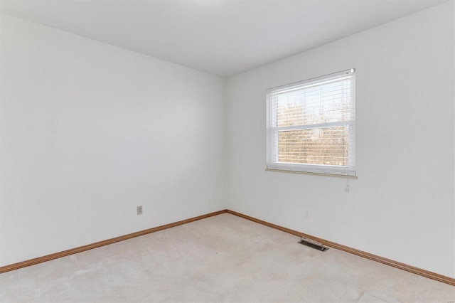 carpeted spare room featuring visible vents and baseboards