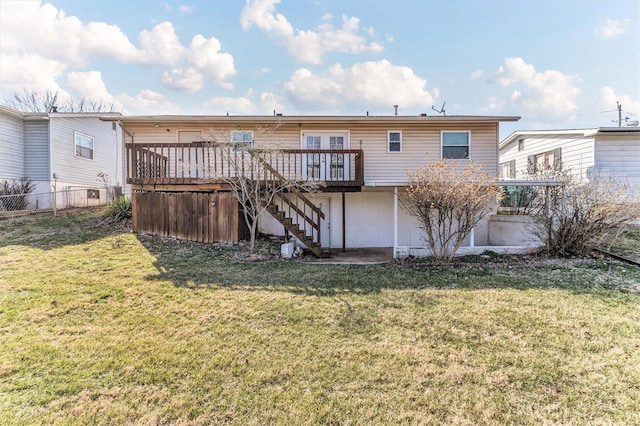 back of property with a deck, a yard, fence, and stairs