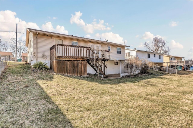 rear view of property featuring a fenced backyard, a lawn, stairs, and a deck