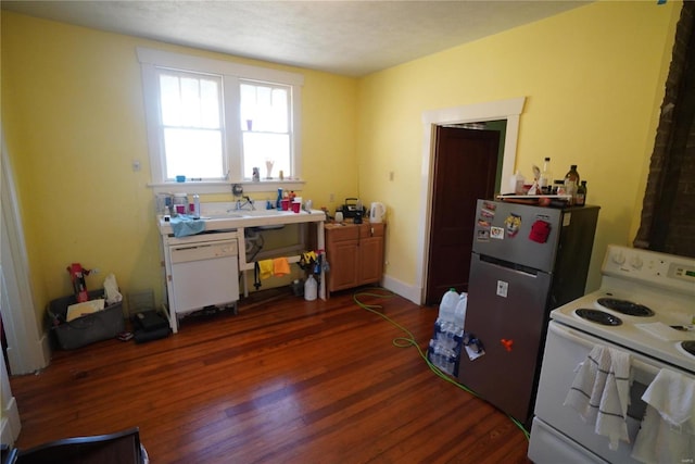 kitchen with dark wood finished floors, white electric range oven, freestanding refrigerator, and a sink