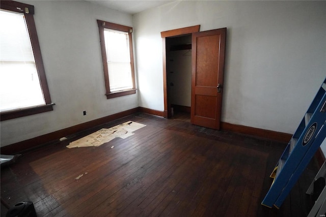 unfurnished bedroom featuring dark wood-style floors and baseboards