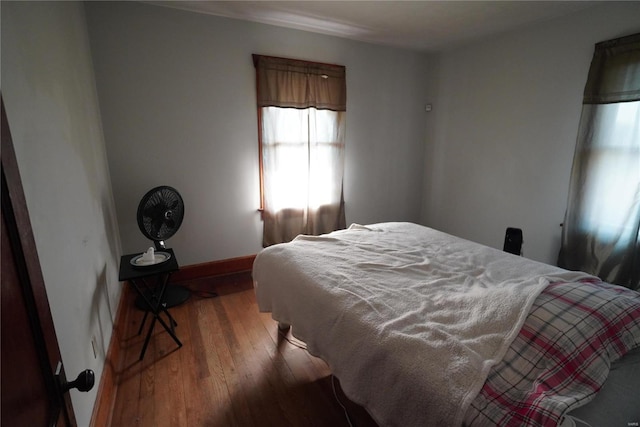 bedroom featuring baseboards and wood-type flooring