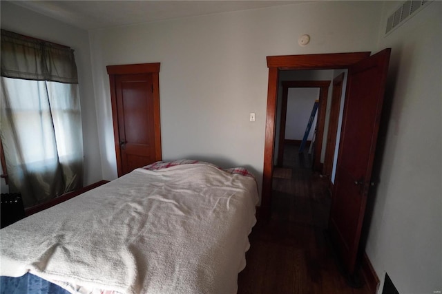 bedroom featuring visible vents and dark wood-type flooring