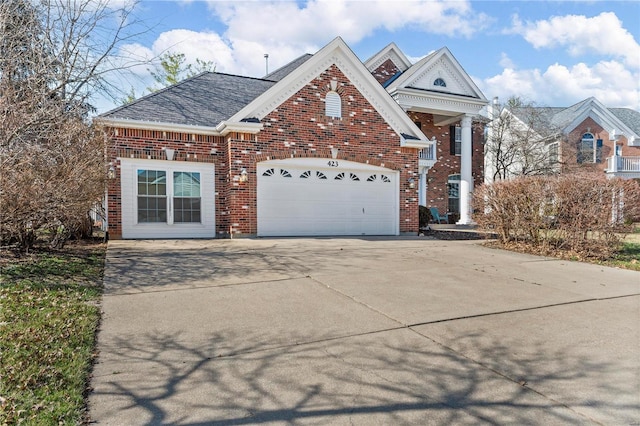 view of front facade featuring a garage, brick siding, and driveway