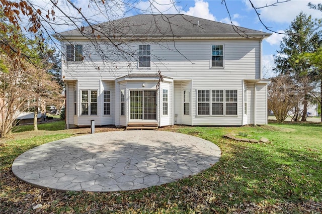 rear view of house featuring a yard and a patio