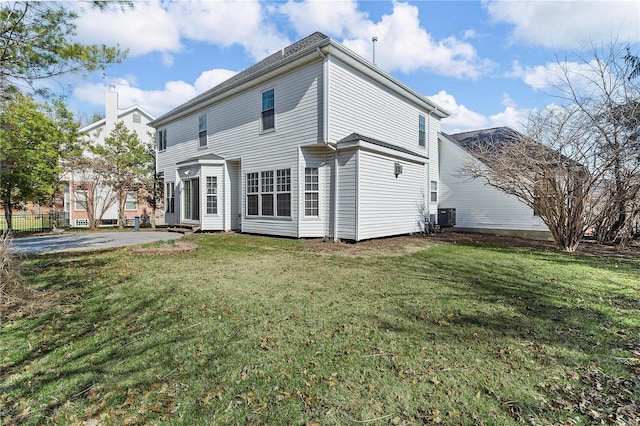 back of house featuring a yard and central AC