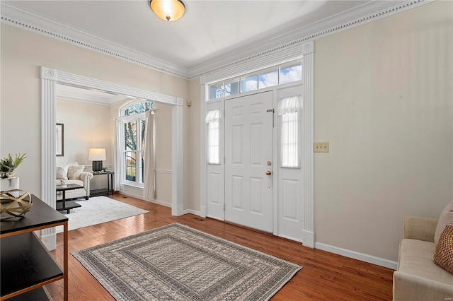 foyer with crown molding, baseboards, and hardwood / wood-style floors