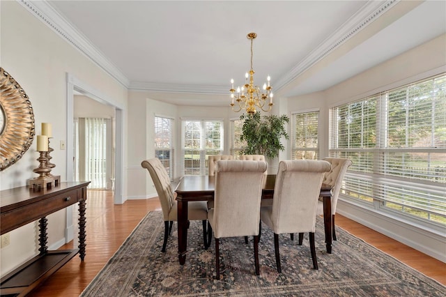 dining space with a notable chandelier, crown molding, baseboards, and wood finished floors