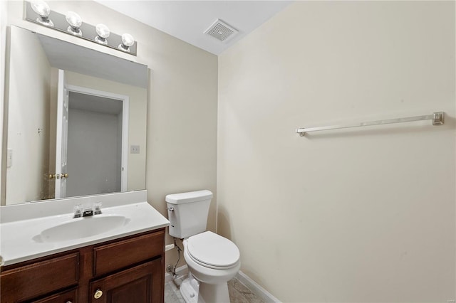 bathroom featuring visible vents, toilet, vanity, and baseboards