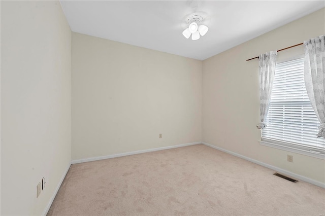 unfurnished room with visible vents, baseboards, and carpet