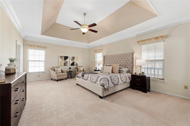 bedroom with a tray ceiling, light carpet, and multiple windows