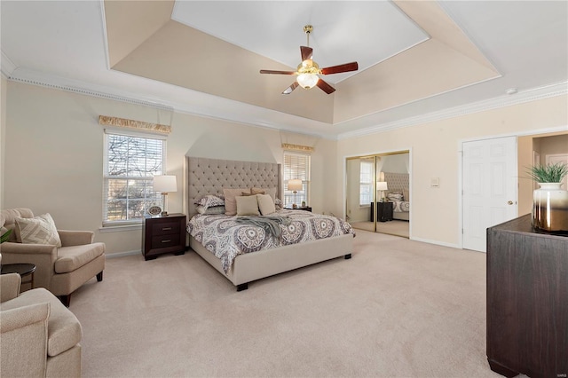 bedroom with baseboards, a raised ceiling, light carpet, and crown molding