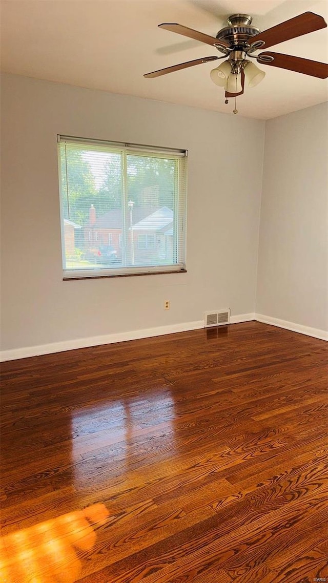 unfurnished room featuring visible vents, ceiling fan, baseboards, and wood finished floors