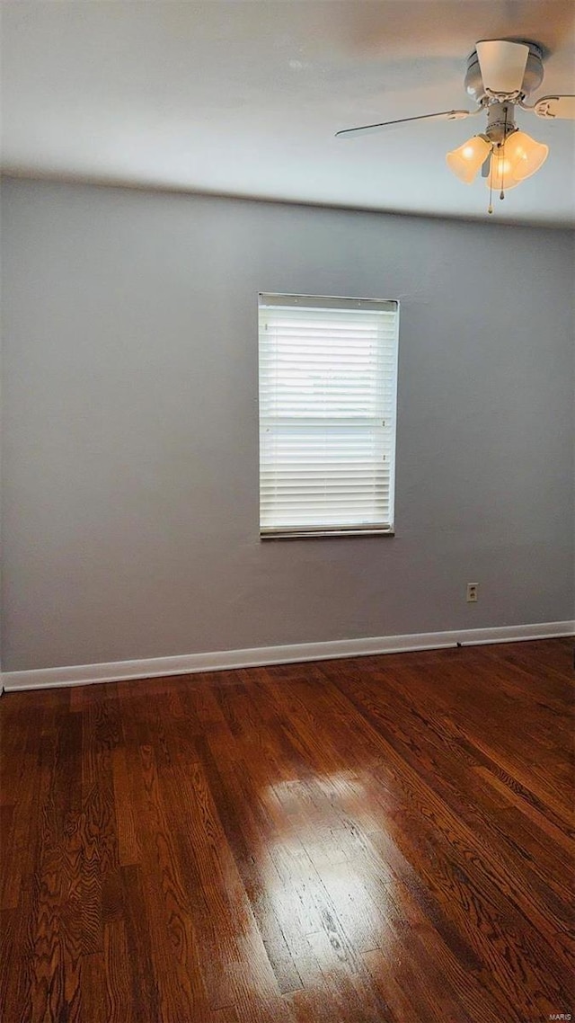 empty room featuring baseboards, wood finished floors, and a ceiling fan