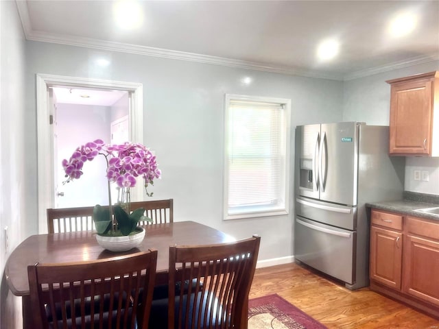 dining area with baseboards, light wood-style floors, and ornamental molding