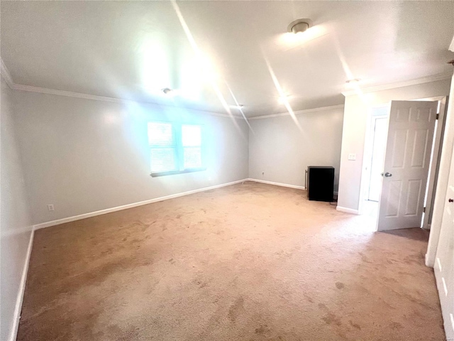 additional living space with baseboards and light colored carpet