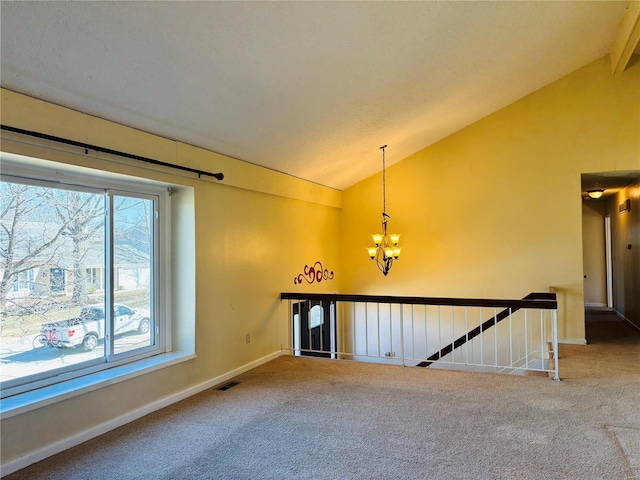 carpeted empty room with a chandelier, visible vents, baseboards, and lofted ceiling