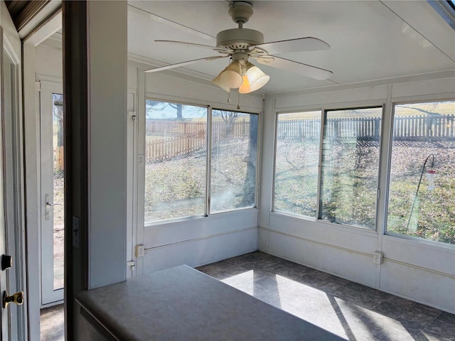 unfurnished sunroom featuring a ceiling fan