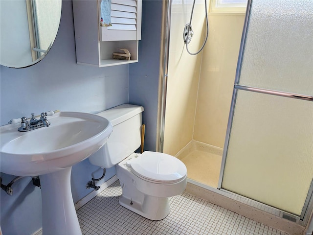 full bath with tile patterned flooring, a shower stall, toilet, and baseboards