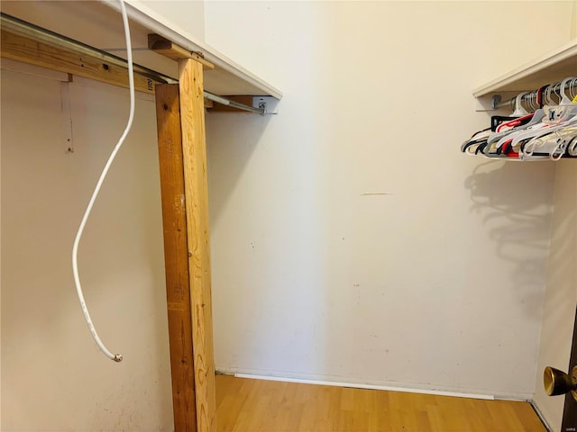 walk in closet with wood finished floors