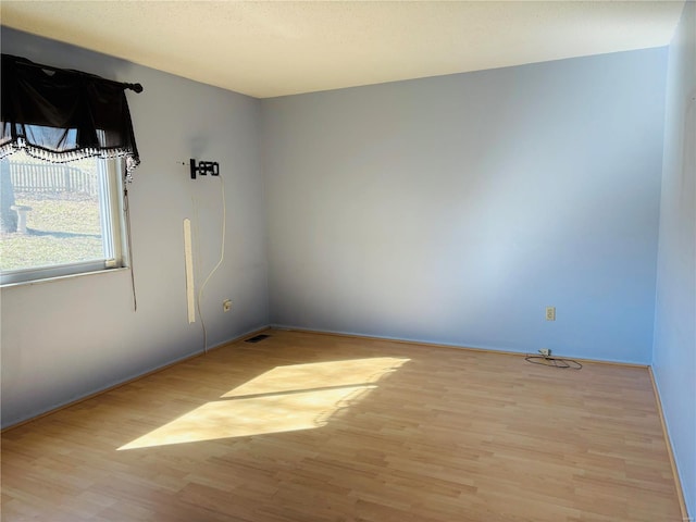 empty room with visible vents and wood finished floors