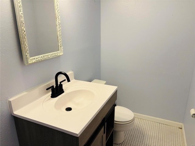 bathroom with vanity, toilet, baseboards, and tile patterned flooring